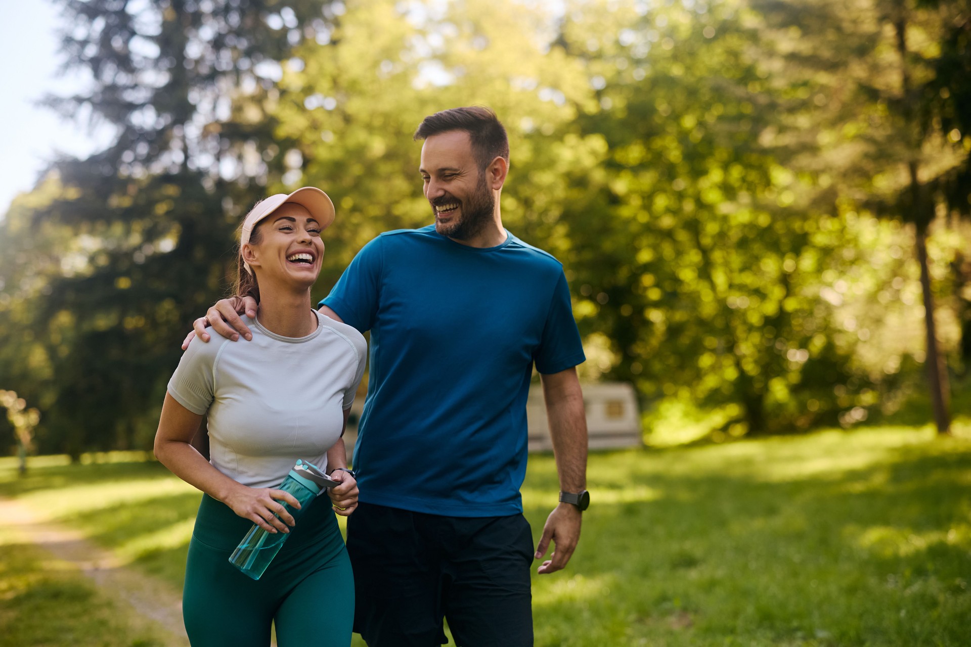 Happy couple laughing while working out in the park.